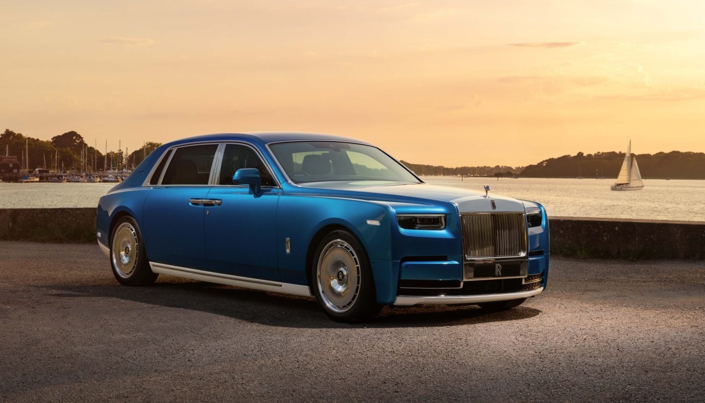 Компанія Rolls-Royce створила ексклюзивний Phantom Regatta в єдиному екземплярі. Спеціальну версію побудували на базі подовженого Phantom Extended, а її світова прем'єра відбудеться на Фестивалі швидкості в Гудвуді. Про це пише Carscoops. Rolls-Royce Phantom Regatta створили за мотивами гоночних яхт Новинка стала даниною гоночним яхтам південного узбережжя Англії. Автомобіль має довжину 5982 мм, що робить його довшим за Cadillac Escalade ESV. Кузов отримав двоколірне оформлення Regatta Blue та English White. За задумом дизайнерів, межа між кольорами нагадує ватерлінію яхти. Образ доповнюють поліровані 22-дюймові диски, виконані у стилі сталевих лебідок, які використовуються на спортивних вітрильниках, а також численні хромовані елементи. Салон також виконаний у морській тематиці. Передню частину оздобили шкірою Navy Blue із контрастною прострочкою Grace White, двоколірним кермом та білими рамками дефлекторів вентиляції. На передній панелі розмістили створену вручну художню композицію Watercolour, натхненну морськими пейзажами. Для її виготовлення Rolls-Royce розробила спеціальні фарби та нову техніку змішування кольорів. Унікальний Phantom Regatta отримав оздоблення у стилі палуби яхти Задня частина салону оформлена у зворотній кольоровій схемі: білі крісла Grace White поєднані із синіми декоративними елементами. Два окремі сидіння розділяє центральна консоль із дерев'яним оздобленням у візерунку «ялинка». Відкидні столики для задніх пасажирів стилізовані під палубу яхти. Кожен із них майстри виготовляли близько 120 годин із 16 планок деревини Royal Walnut, доповнених вставками з Black Bolivar. Автомобіль також отримав підсвічувані дверні панелі та ексклюзивну стелю Starlight Headliner із 1307 оптоволоконними елементами, що імітують припливні течії навколо острова Вайт. Очікується, що Phantom Regatta оснащений 6,75-літровим бензиновим двигуном V12 із подвійним турбонаддувом потужністю 563 к.с. і 900 Нм крутного моменту. Подовжений седан розганяється від 0 до 96 км/год за 5,2 секунди, а його максимальна швидкість становить 250 км/год.